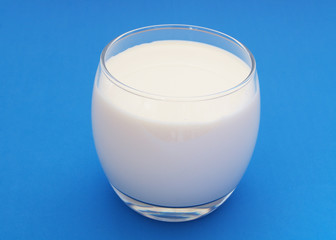 Glass of milk on blue background