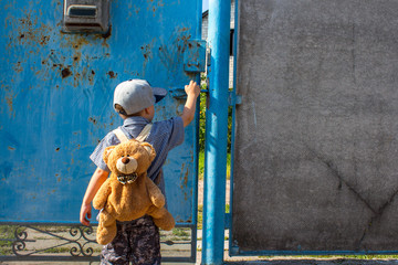 a little boy in the yard with a backpack