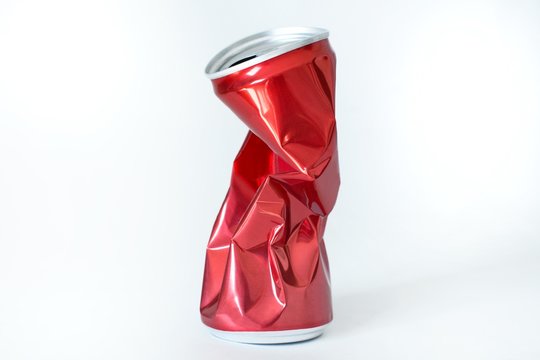 squeezed red soda can on white background