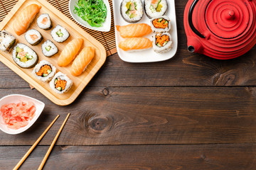 Sushi rolls and sashimi served on bamboo plate