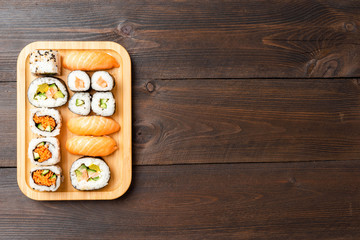 Sushi rolls and sashimi served on bamboo plate