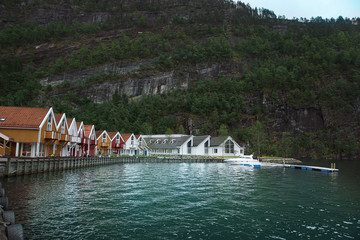 Travel to Norway, a small village on the shore of the fjord, bright houses stand in a semicircle on the waterfront