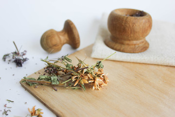  Herbal tea made from Hypericum and Oregano on a wooden board, wooden spoon and wooden bamboo mortar