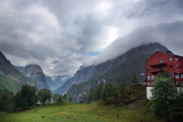 Fototapeta na wymiar Travel to Norway, a large house or hotel stands on the edge of the valley, beyond which the mountains begin