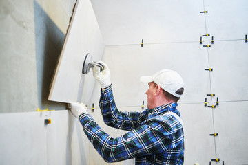 Tiler installing large format tile on wall. home indoors renovation