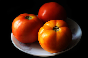 Fresh tomato on black background