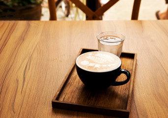 Hot latte with beautiful latte art on the wooden table