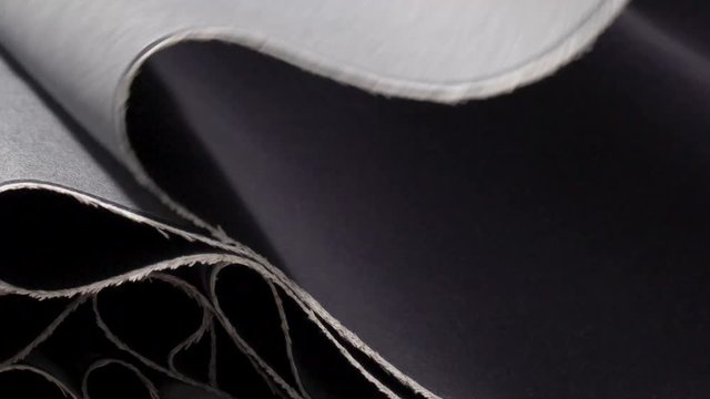 Medium shot of denim fabric folding in to place on top of one another.