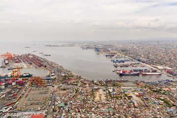 Trading port in Manila. Cargo cranes and containers in the port. Landscape.