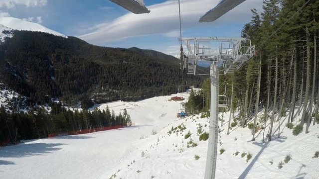 POV backwards to black Tomba slope from skier riding on ski lift in Bansko Bulgaria