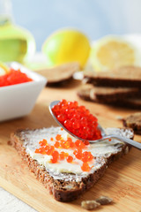 Caviar, bread, lemons and cutting board on light background, space for text