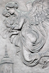 A sandstone relief of a female angel who carries a young child.