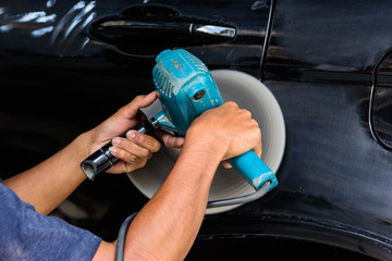 The man polish the car by polishing machine