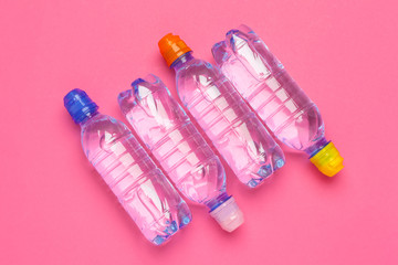 Plastic bottles with pure water on pink background top view space for text