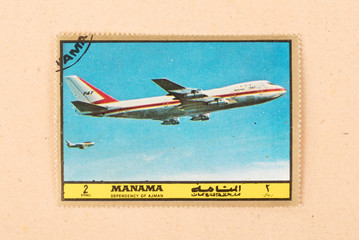 UNITED ARAB EMIRATES - CIRCA 1980: A stamp printed in the UAE shows an old airplane (Boeing 747),...
