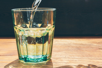Glass of water on dark background close up