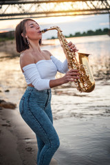 Woman playing the saxophone at sunset