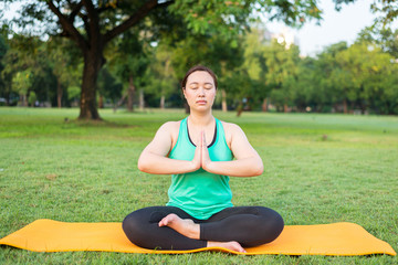 Portrait of gorgeous young woman practicing yoga outdoor.