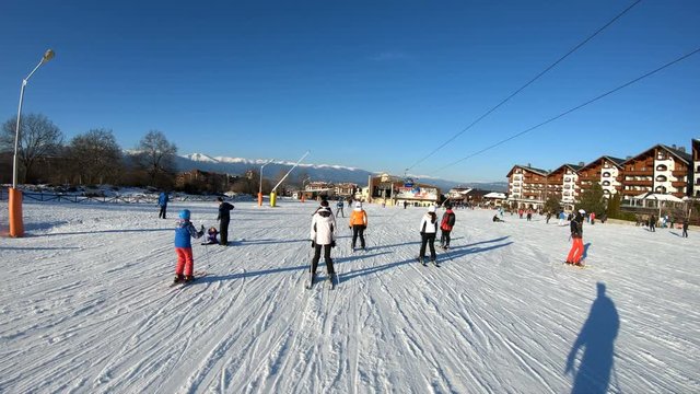 Crowd of people on ski road just before the sunset in Bansko Bulgaria. Bansko is a popular winter ski resort where a world ski cup is held. Slow motion cinematic shot