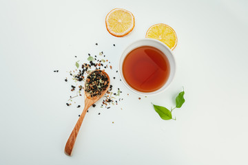  layout made of cup of black tea and leaves on a white background. Top view