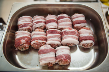 Meat products: cutlets, stuffed cabbage, meatballs in bacon. Fresh appetizing meat store products in metal trays