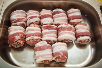 Meat products: cutlets, stuffed cabbage, meatballs in bacon. Fresh appetizing meat store products in metal trays