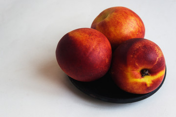 Nectarine on a black saucer. Candid.