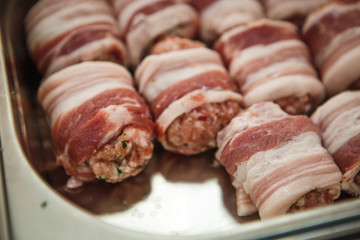 Meat products: cutlets, stuffed cabbage, meatballs in bacon. Fresh appetizing meat store products in metal trays