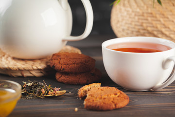 glass teapot with cup of black tea on wooden table