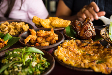Tasty looking Indonesian food served on the table with a variety of chili sauces, rice, prawns, chicken and omlette.