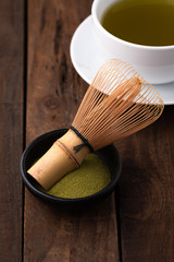 tea whisk for matcha with green tea in cup on wood