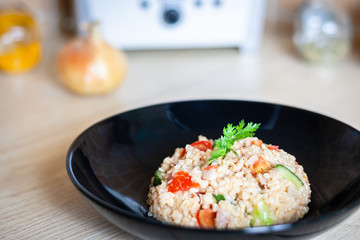 Bulgur salad with vegetables on the kitchen table with ingredients. Arabic couscous salad.