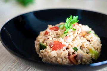 Bulgur salad with vegetables on the kitchen table with ingredients. Arabic couscous salad.