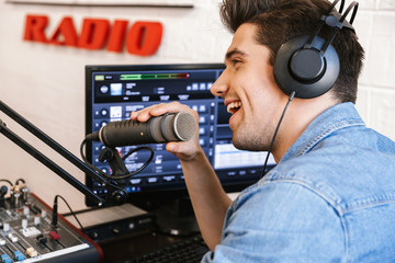 Handsome happy young male radio host broadcasting
