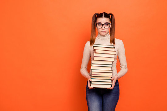 Close Up Photo Beautiful She Her Lady Pretty Hairstyle Bite Lip Oh No Expression Hold Arms Hands Many Books Eyes Full Fear Examination Wear Casual Pastel Pullover Clothes Isolated Orange Background