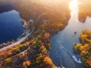 Fototapeta premium aerial (bird's-eye) view of colorful forest, blue river and rocks. Drone shot. natural beautiful autumn landscape