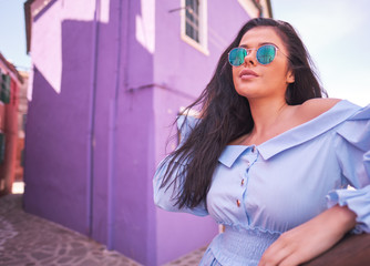 Fototapeta premium tourist woman posing among colorful houses on Burano island, Venice. Tourism in Italy concept