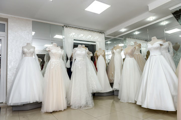 Collection of wedding dresses in showcase of the shop