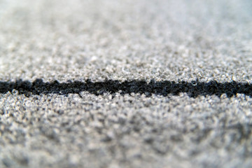 Perspective of grey carpet with black lines background texture, close up, gray textile texture, fluffy rug background. Selective focus.