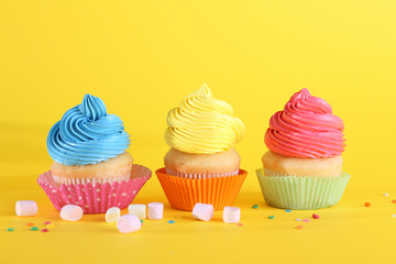Sweet tasty cupcakes on color background
