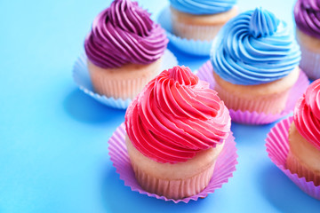 Sweet tasty cupcakes on color background