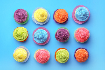 Sweet tasty cupcakes on color background
