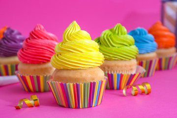 Sweet tasty cupcakes on color background