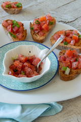 Close up view of tasty tomato Italian appetizers -  bruschetta, on slices of toasted baguette