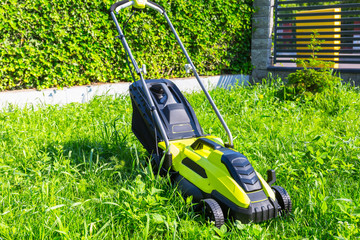 Lawn mower before cutting green grass in backyard