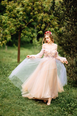 Fototapeta premium beautiful slender girl with dark hair in gentle elegant dress, fairy-tale princess in the spring flowering garden, the gentle image of the queen, fairy in love
