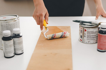 painting furniture, close-up hand with paint roller