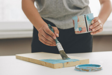 painting furniture, close-up hand with brush