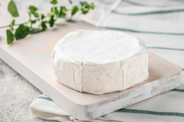 Wooden board with brie cheese. Italian antipasti snacks. French camembert cheese. Close-up.