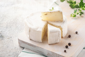 Wooden board with brie cheese. Italian antipasti snacks. French camembert cheese. Close-up.